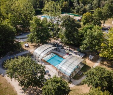 Piscine couverte dans un écrin de verdure au Huttopia Les Châteaux