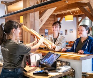 Réception intérieure avec hôtes au comptoir du camping Huttopia Les Châteaux
