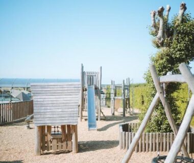 Aire de jeux en bois avec vue sur la mer au camping Huttopia Les Falaises Normandie