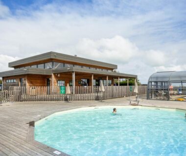Piscine extérieure et terrasse en bois au camping Huttopia Les Falaises
