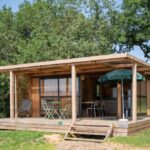 Terrasse couverte avec mobilier et parasol du chalet Huttopia Meursault