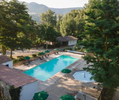 Piscine extérieure entourée d'arbres au camping Huttopia Millau