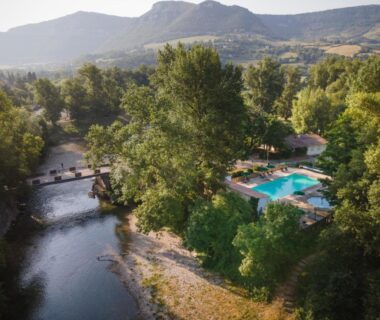 Bord de rivière avec piscine et chaises longues au Huttopia Millau
