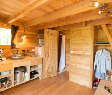 Intérieur de cabane en bois avec kitchenette et placard au camping Huttopia Pays de Cordes sur Ciel