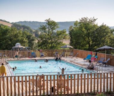Piscine extérieure entourée de collines au camping Huttopia Pays de Cordes sur Ciel