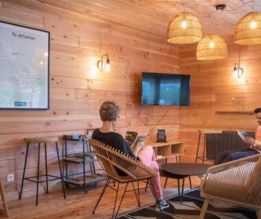 Salon intérieur avec fauteuils et télévision au camping Huttopia Pays de Cordes sur Ciel