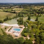 Piscine extérieure et étang au camping Huttopia Pays des Bastides