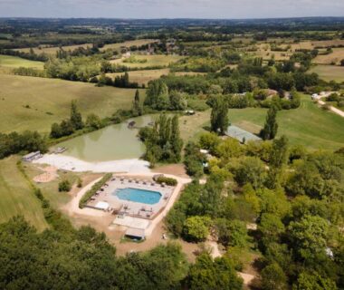 Piscine extérieure et étang au camping Huttopia Pays des Bastides