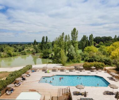 Piscine extérieure et solarium au bord d'un lac au Huttopia Pays des Bastides