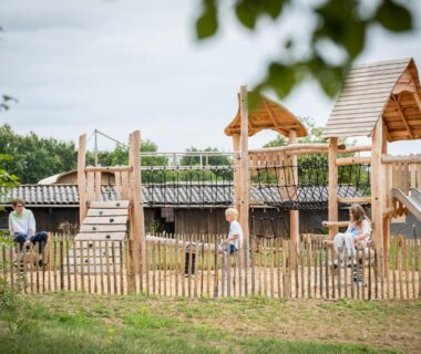 Aire de jeux en bois avec toboggan et bancs au Huttopia Pays des Bastides