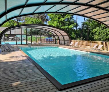 Piscine couverte avec solarium sur terrasse en bois au Huttopia Rambouillet