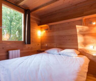 Chambre en bois avec lit double au Huttopia Rambouillet