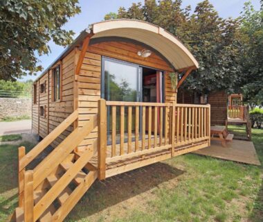 Roulotte en bois avec terrasse sur pelouse au Huttopia Rambouillet