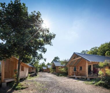 Allée et chalets en bois dans le camping Huttopia Royat