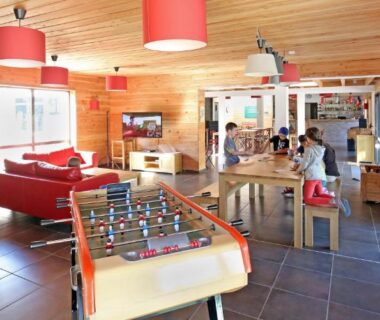 Salle de jeux avec babyfoot et canapés au Huttopia Royat