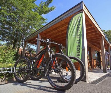 Entrée avec vélos et bannière au Huttopia Royat