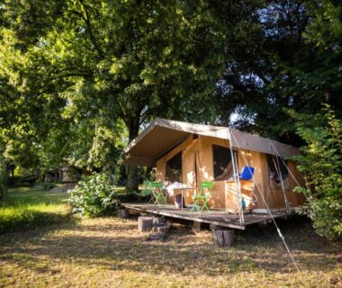 Bungalow toile sur pilotis dans une clairière au camping Huttopia Sarlat