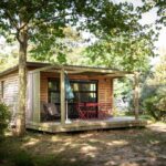Chalet en bois sur terrasse ombragée au Huttopia Saumur