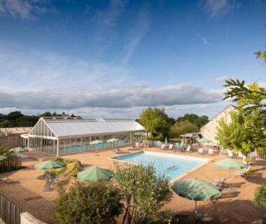 Piscine extérieure et solarium au Huttopia Saumur