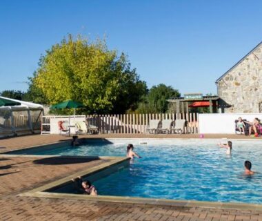 Piscine extérieure avec baigneurs au camping Huttopia Saumur