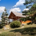 Chalets en bois dans un paysage de montagne au Huttopia Val Cenis