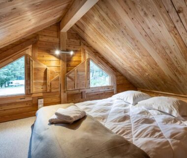 Chambre mansardée avec lit et fenêtres dans l'hébergement Huttopia Val Cenis
