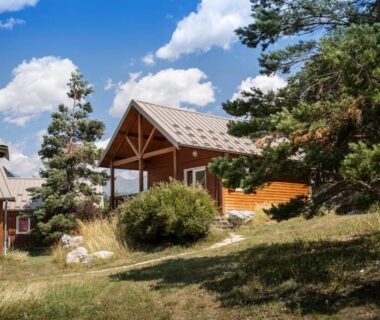 Chalets en bois dans un paysage de montagne au Huttopia Val Cenis