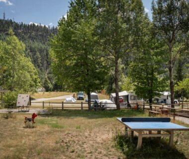 Emplacement herbeux avec table de ping-pong et aire de jeux au camping Huttopia Val Cenis