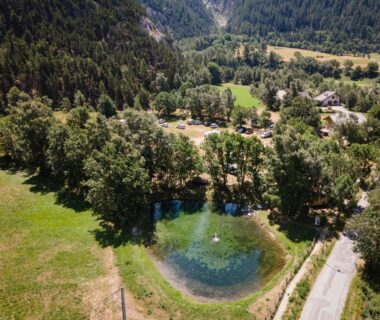 Étang au milieu des arbres dans le camping Huttopia Val Cenis
