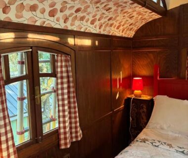 Chambre de roulotte avec lit et lampe dans la roulotte Idyllic Roulotte