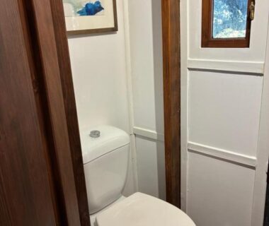 Toilettes intérieures avec fenêtre et lambris dans la roulotte Idyllic Roulotte
