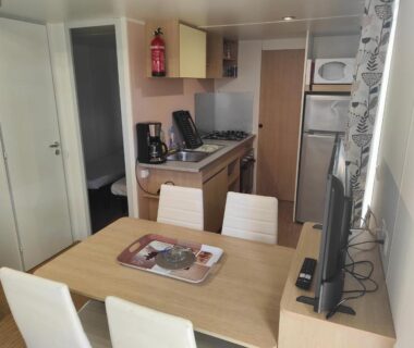 Mobil-home intérieur avec table chaises et kitchenette dans l'Indivision Courbin Pebay Jérémy et Alexia