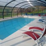 Piscine couverte avec transats rouges et bleus aux Insolites de la Tellerie