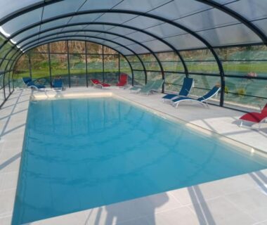 Piscine couverte avec chaises longues dans la campagne au camping Insolites de la Tellerie