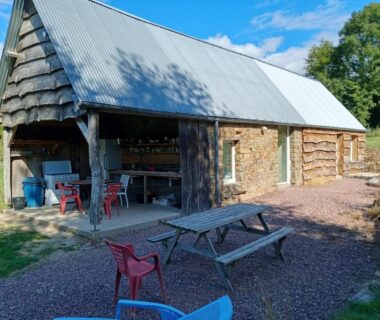 Abris extérieur avec tables et bancs au camping Insolites de la Tellerie