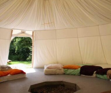 Intérieur de yourte avec tapis et coussins dans les Insolites de la Tellerie