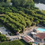 Vue aérienne du camping avec piscine et emplacements verdoyants à l'International Camping Ardèche