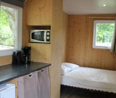 Intérieur avec coin cuisine et lit dans un hébergement de l'International Camping Ardèche