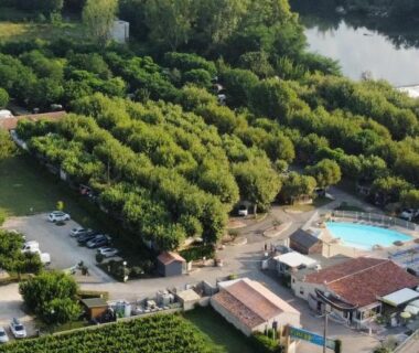 Vue aérienne du camping avec piscine et emplacements verdoyants à l'International Camping Ardèche