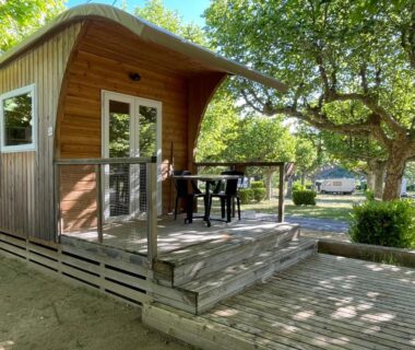 Terrasse en bois avec table et chaises à l'International Camping Ardèche