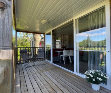 Terrasse en bois avec baie vitrée donnant sur paysage au International Camping Ardèche