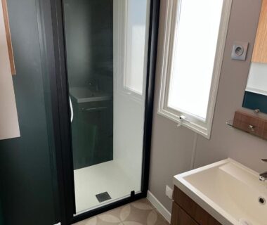 Salle de bain avec douche vitrée et lavabo dans le JP L'Eleganzia 2 ch