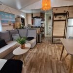 Séjour avec canapé kitchenette et coin repas dans le Joli Bungalow Cap Ferret Camping les Viviers
