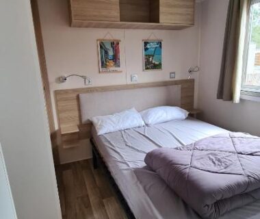 Intérieur chambre double avec lit rangements et fenêtre dans le Joli Bungalow Cap Ferret Camping les Viviers