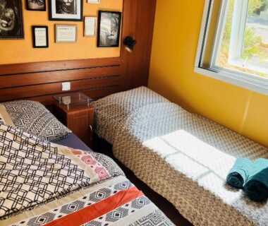 Chambre avec deux lits et cadres muraux dans le mobil-home Joli Mobil-Home de Vacances