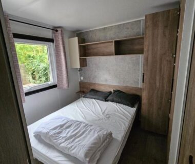Chambre avec lit double et fenêtre dans le mobil home Jolie Mobil home 103