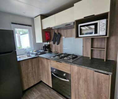 Cuisine équipée avec réfrigérateur four et micro-ondes dans le mobil-home Jolie Mobil home 103