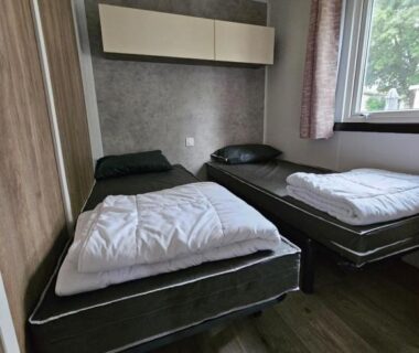 Chambre avec deux lits simples et fenêtre dans le mobil home Jolie Mobil home 103