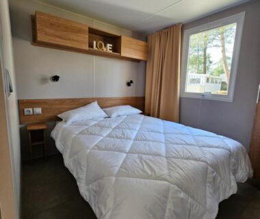Chambre avec lit double et fenêtre dans le mobil home Jolie Mobil home 2 chambres (198)
