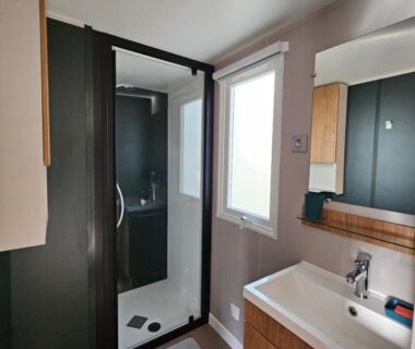 Salle de bain avec douche vitrée lavabo et fenêtre dans le Jolie Mobil home 2 chambres (198)